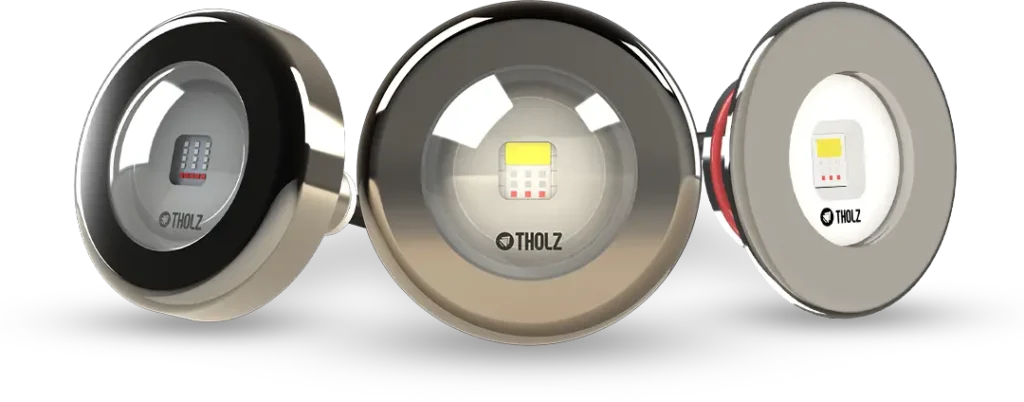 Tres reflectores de piscina Tholz en diferentes acabados metálicos, con tecnología de iluminación LED integrada.