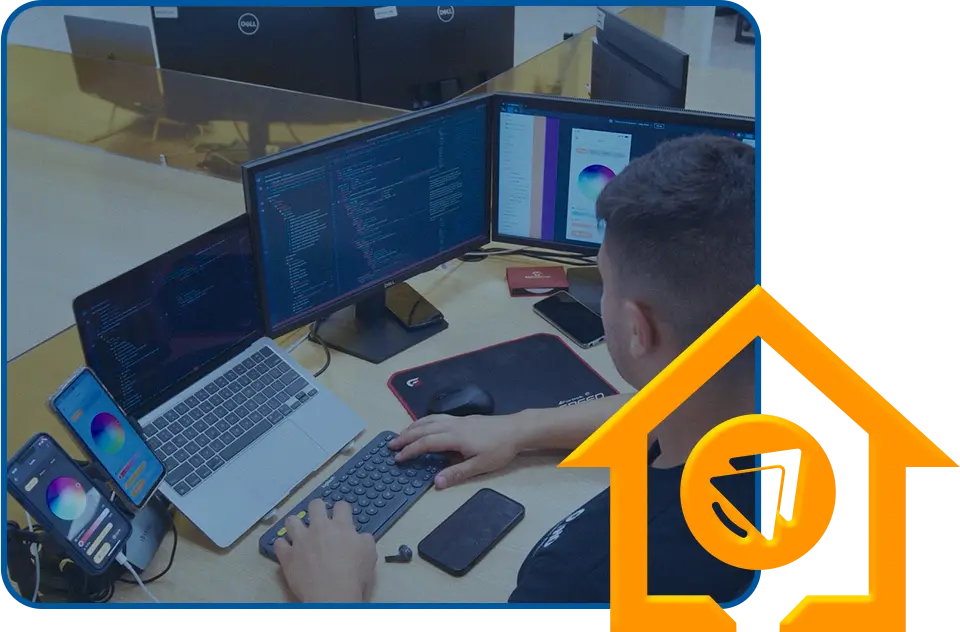 Desarrollador trabajando en una estación con varios monitores y smartphones, programando y probando interfaces de aplicaciones de automatización, con un ícono de casa inteligente en color amarillo superpuesto.