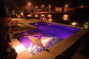 Piscina iluminada com refletores LED Tholz, criando o ambiente perfeito para aproveitar a piscina à noite com segurança, economia e estilo.